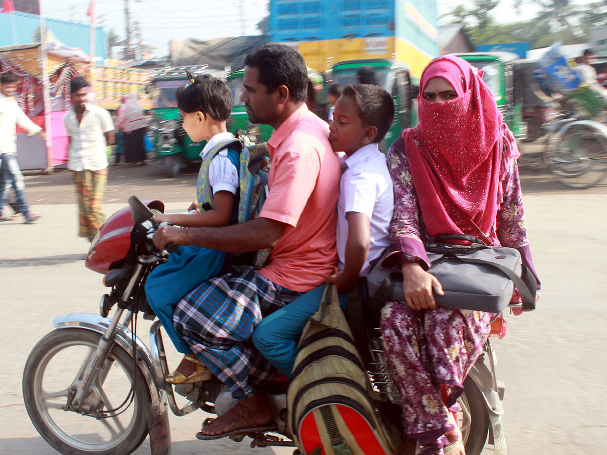 Four people riding a motorbike at Shambhuganj area of Mymensingh as no one wears helmet. Photo: Anwer Hossain