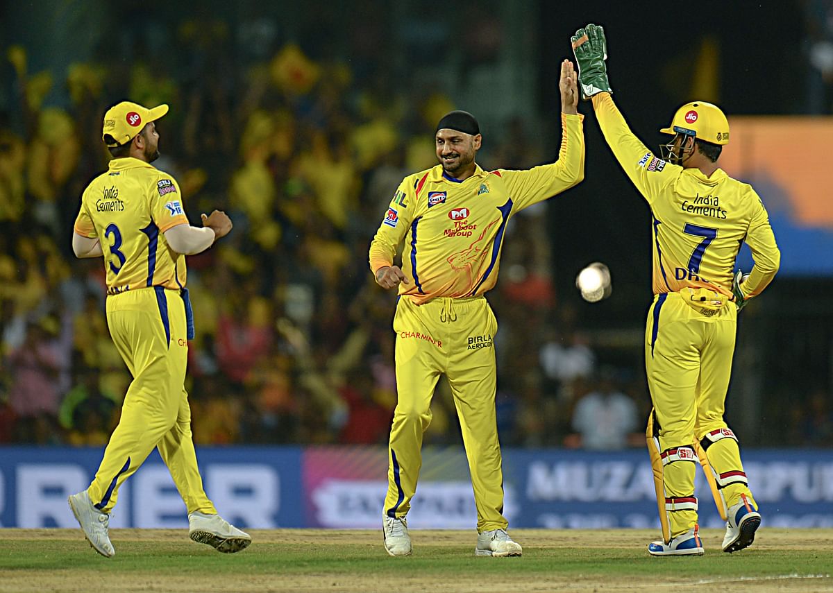 Chennai Super Kings cricketer Harbhajan Singh (C) along with Mahendra Singh Dhoni (R) celebrate a wicket of Royal Challengers Bangalore`s VIrat Kohli during the Indian Premier League (IPL) Twenty20 cricket match at the MA Chidhambaram Stadium in Chennai on 23 March 2019. Photo: AFP