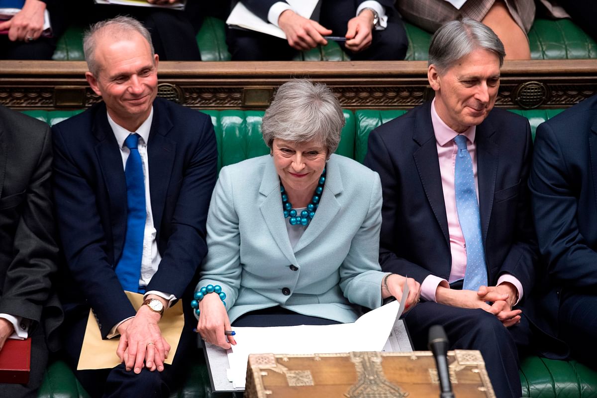 A handout photograph released by the UK parliament shows Britain`s minister for the Cabinet Office and Chancellor of the Duchy of Lancaster David Lidington (L), Britain`s prime minister Theresa May (C) and Britain`s Chancellor of the Exchequer Philip Hammond (R) listening to questions in the House of Commons in London on 25 March 2019 on the next steps that parliament will take in the Brexit process. Photo: AFP