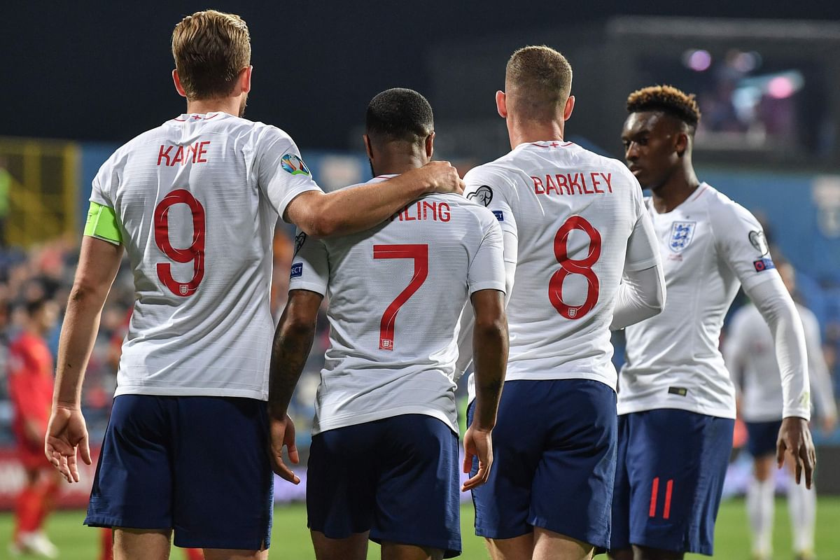 England`s forward Raheem Sterling (C-L) is congratulated by England`s forward Harry Kane (L) and England`s midfielder Ross Barkley (R) after scoring the fifth goals of his team during the Euro 2020 football qualification match between Montenegro and England at Podgorica City Stadium on 25 March 2019 in Podgorica, Montenegro. Photo: AFP