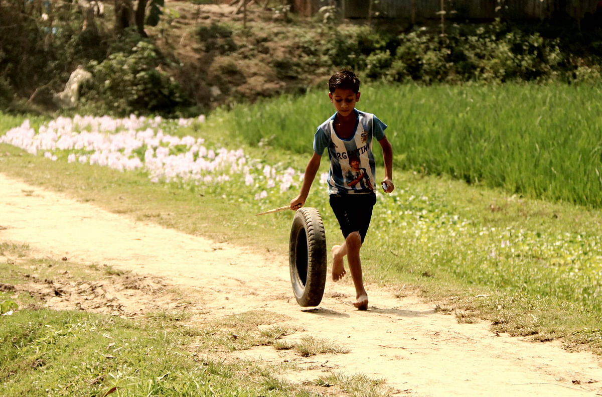 Child playing with a tyre at Bilghor, Kosba in Brahmanbaria. A recent photo by Emdadul Haque