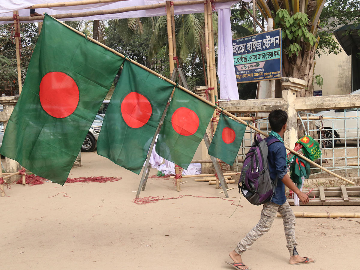 A man carries the national flag of Bangladesh on the eve of Indpendence Day at Shapla Chattar Road in Khagrachhari on 24 March 2019. Photo: Nerob Chowdhury