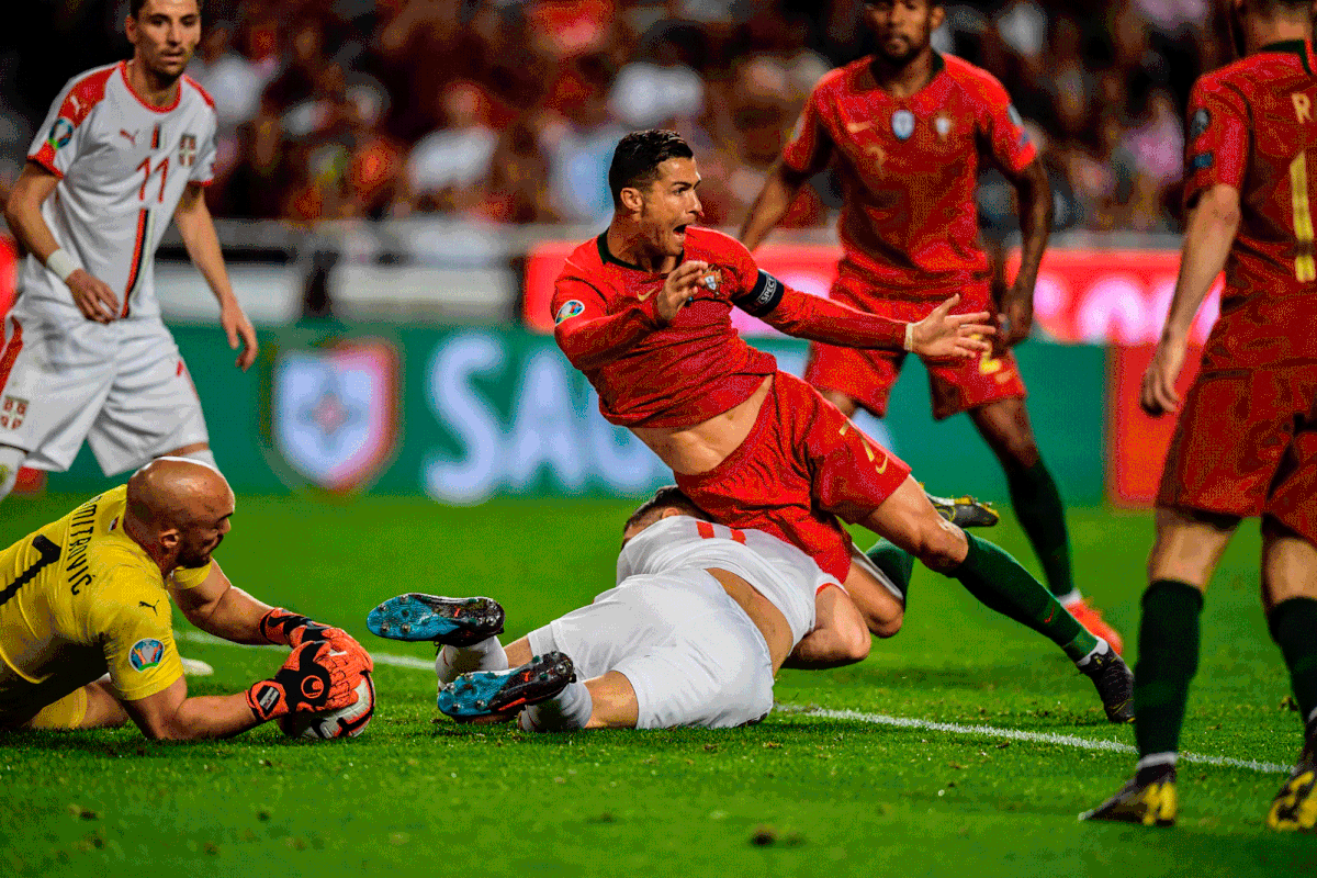 Portugal`s forward Cristiano Ronaldo (C) vies with Serbia`s defender Nikola Milenkovic (BOTTOM) during the Euro 2020 qualifying group B football match between Portugal and Serbia at the Luz stadium in Lisbon on 25 March 2019. Photo: AFP
