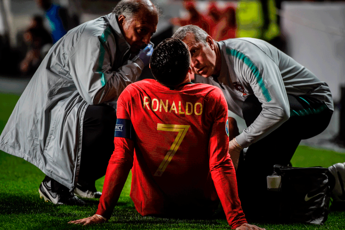 Doctors check on Portugal`s forward Cristiano Ronaldo during the Euro 2020 qualifying group B football match between Portugal and Serbia at the Luz stadium in Lisbon on 25 March 2019. Photo: AFP