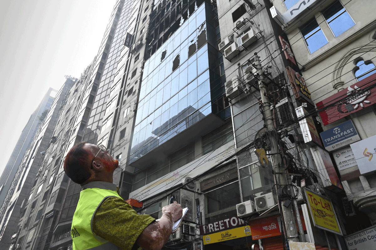 A Bangladeshi forensic expert looks on as he works at the scene of the burnt building in Dhaka on 29 March 2019, a day after flames tore through the 22-storey FR Tower. Photo: AFP