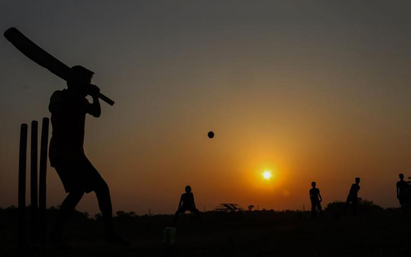 Young boys playing cricket against a sunset background in Batiaghata of Khulna on 29 March, 2019. Photo: Saddam Hossain