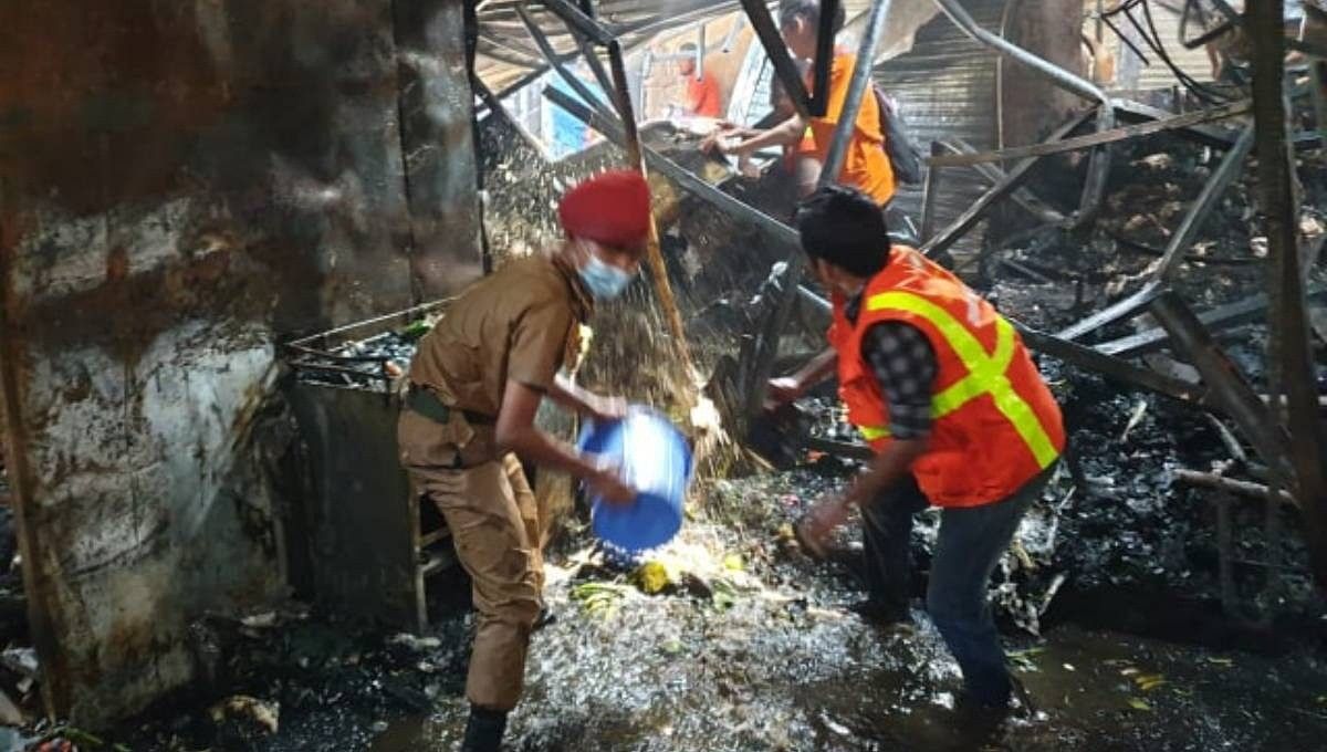 Firefighters with the help of securities douse the fire at Gulshan-1 DNCC kitchen market in Dhaka on Saturday morning. Photo: UNB