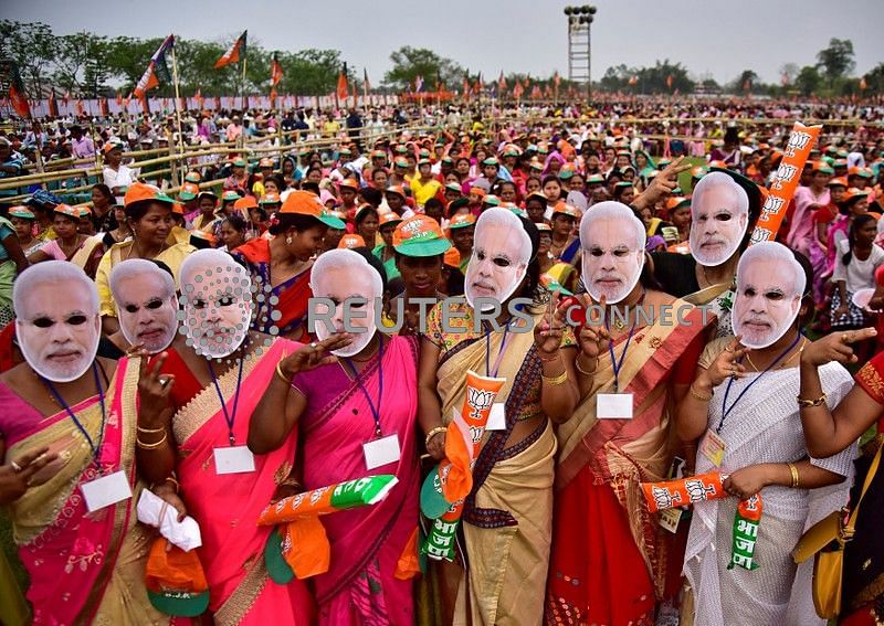 Supporter of India`s ruling Bharatiya Janata Party (BJP) wearing masks of prime minister Narendra Modi attend an election campaign rally addressed by Modi at Moran town in the northeastern state of Assam, India, on 30 March 2019. Photo: Reuters