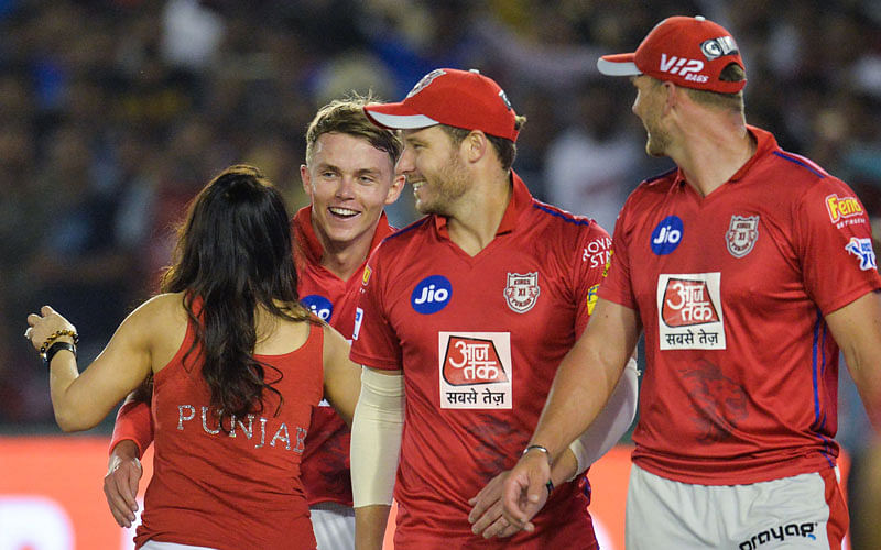 Kings XI Punjab’s bowler Sam Curran (L) celebrates with his team owner Preity Zinta and team mates after he took a hatrick (3 wickets in three balls) during the 2019 Indian Premier League (IPL) Twenty20 cricket match between Kings XI Punjab and Delhi Capitals at the Punjab Cricket Association Stadium in Mohali on 1 April 2019. Photo: AFP
