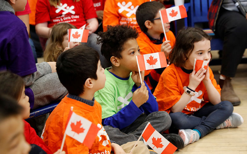 Kids hold Canadian flags before Canada’s Finance Minister Bill Morneau holds a pre-budget photo opportunity in Toronto, Ontario, Canada on 14 March. Reuters File Photo