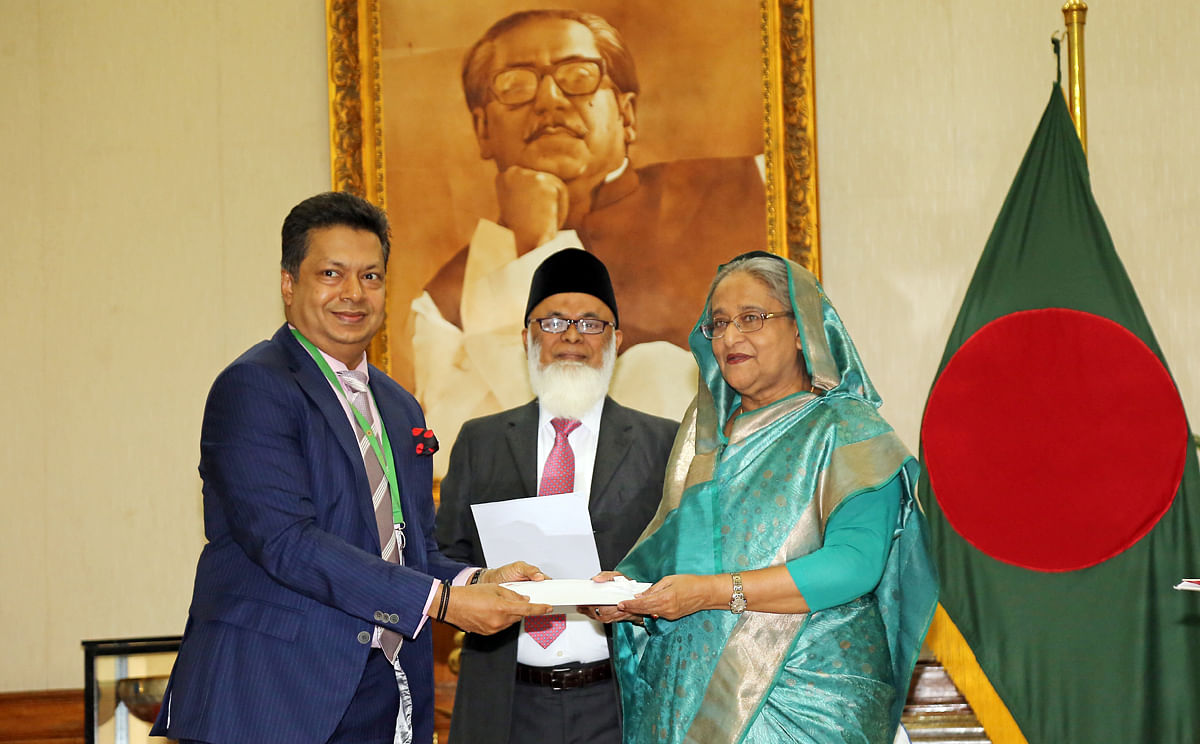 City Bank chairman of Aziz Al Kaiser hands over a cheque of Tk 10 million to prime minister Sheikh Hasina on Tuesday. Photo: Collected