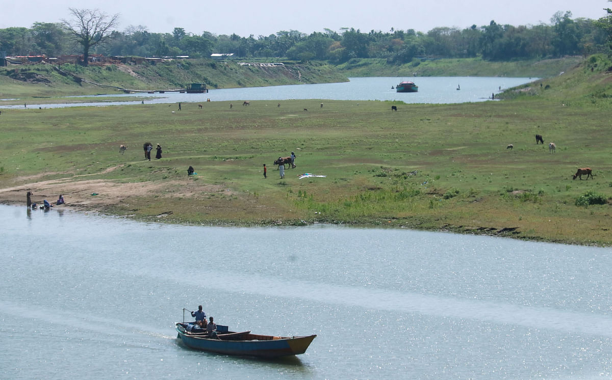 A boat running along the river Surma in Kushighat, Sylhet on 3 April 2019. Sandbars rise and the locals bring cattle for grazing here during the dry season. Photo: Anis Mahmud