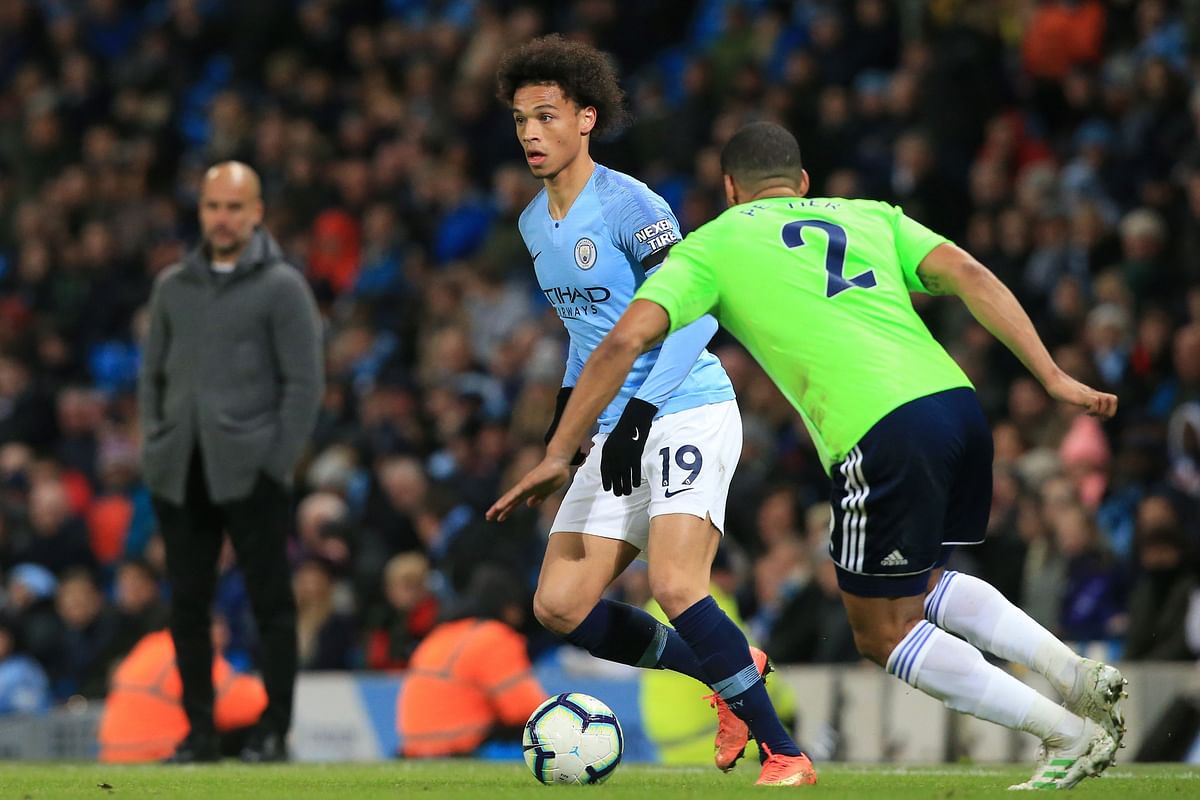 Manchester City`s Spanish manager Pep Guardiola (L) watches as Manchester City`s German midfielder Leroy Sane (C) vies with Cardiff City`s English defender Lee Peltier during the English Premier League football match between Manchester City and Cardiff City at the Etihad Stadium in Manchester, north west England, on 3 April 2019. Photo: AFP