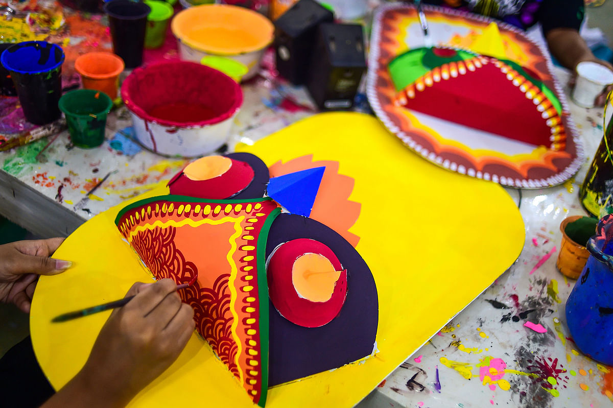 A Bangladeshi student of Dhaka University Art Institute paints a mask to sell as a part of Bengali New Year preparations in Dhaka on 7 April 2019. Photo: AFP