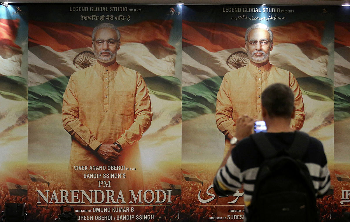 A man uses his mobile phone to take photographs of a poster of the upcoming film `PM Narendra Modi` during the launch of its poster in Mumbai. Photo: Reuters