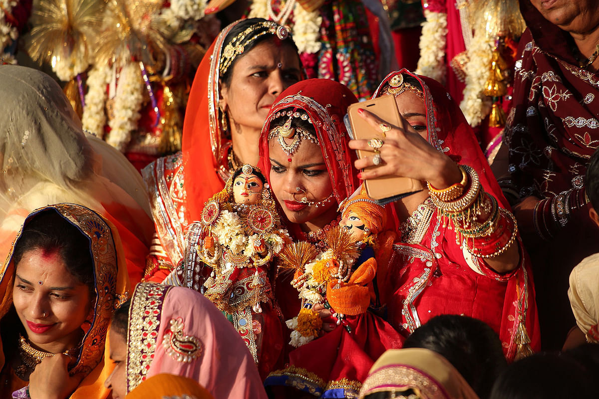 In this photo taken on 8 April 2019, Indian married women take a selfie on a smartphone as they take part in the Gangaur festival in Udaipur, in India`s western Rajasthan state, to worship the Hindu goddess Gauri, consort of the deity Shiva. Photo: AFP