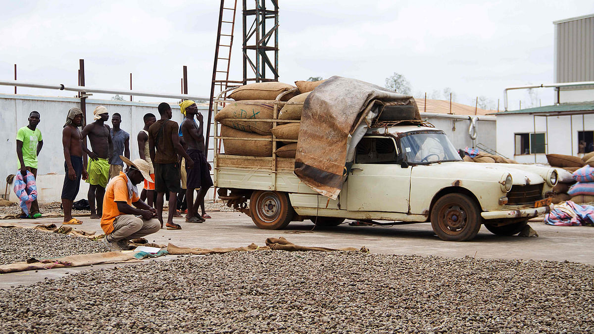 Workers wait to unload bags of cashew nuts from a truck for the drying process at the Fludor plant in Zogbodomey, some 110km north of Cotonou, on 29 March 2019. Photo: AFP
