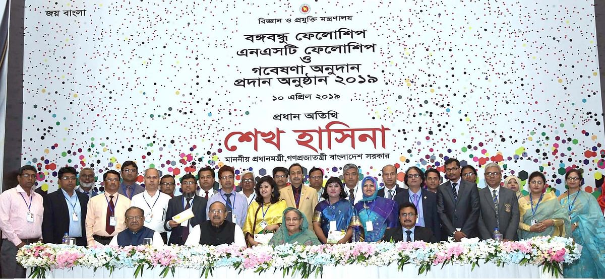 Prime minister Sheikh Hasina takes part in a group photo session after distributing cheques among the post-graduate students and researchers for research at a programme organised by the Ministry of Science and Technology at Bangabandhu International Conference Centre in Dhaka on Wednesday. Photo: PID