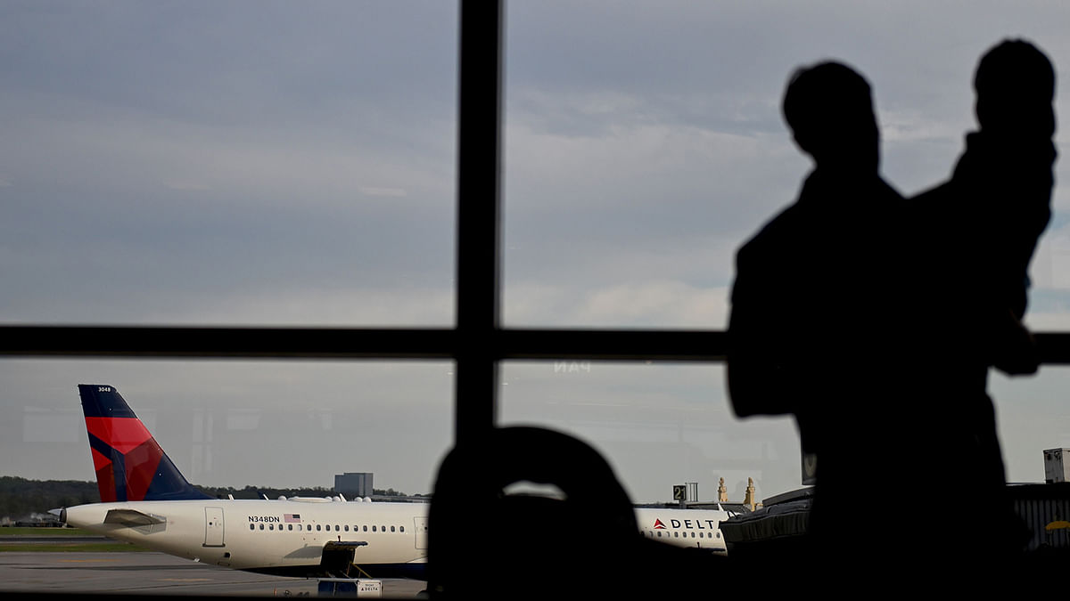 A father holds his daughter as they look at a Delta airplane at Washington Reagan airport in Arlington, Virginia on 10 April 2019. Photo: AFP