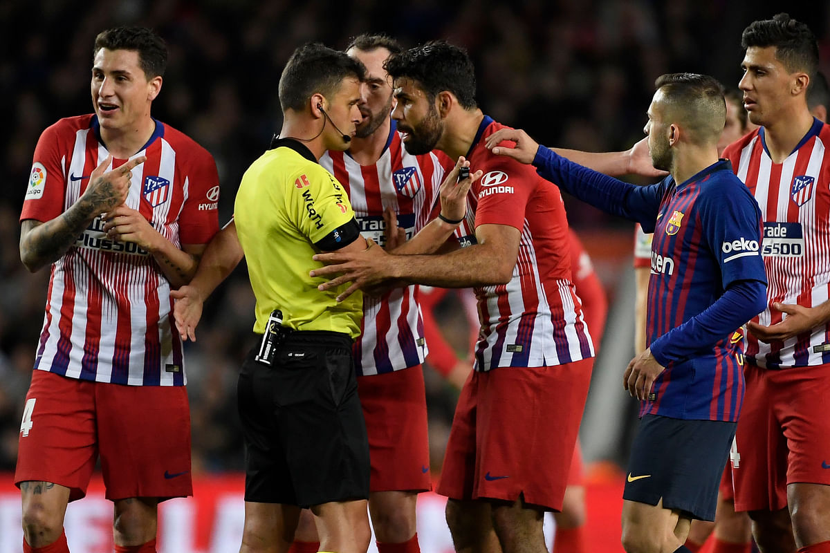 Atletico Madrid's Spanish forward Diego Costa (2R) talks with Spanish referee Gil Manzano prior to receiving a red card during the match between FC Barcelona and Club Atletico de Madrid at the Camp Nou stadium 6 April, 2019. Photo: AFP