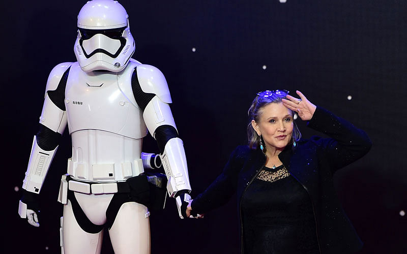 In this file photo taken on 16 December 2015, US actress Carrie Fisher poses with a storm trooper as she attends the opening of the European Premiere of “Star Wars: The Force Awakens” in central London.  Photo: AFP