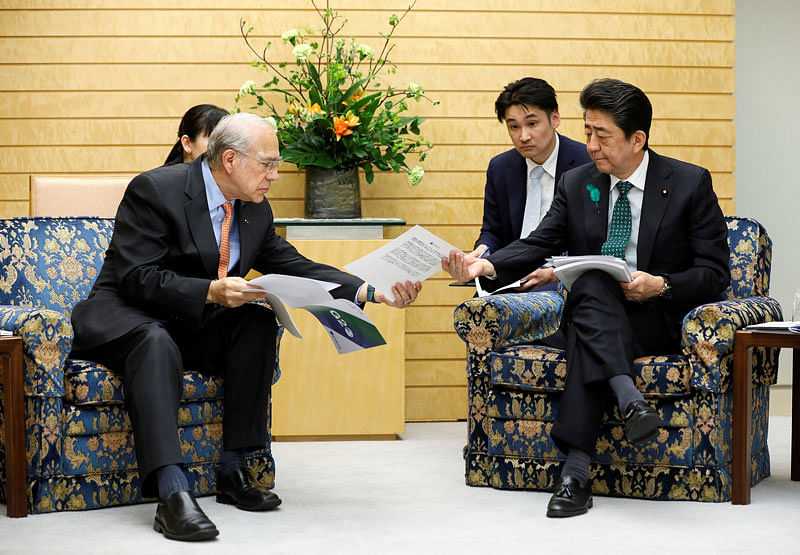 Angel Gurria, Secretary-General of the Organisation for Economic Co-operation and Development (OECD), shows reports about G20 from OECD`s recent annual report to Japanese prime minister Shinzo Abe (R) during a courtesy call at the latter`s official residence in Tokyo, Japan, on 15 April 2019. Reuters File Photo