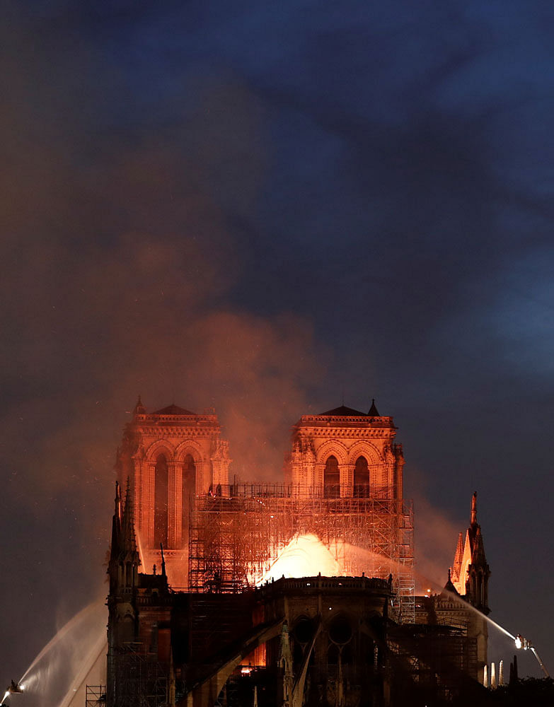 Firefighters douse flames from the burning Notre Dame Cathedral in Paris, France on 15 April. Photo: Reuters