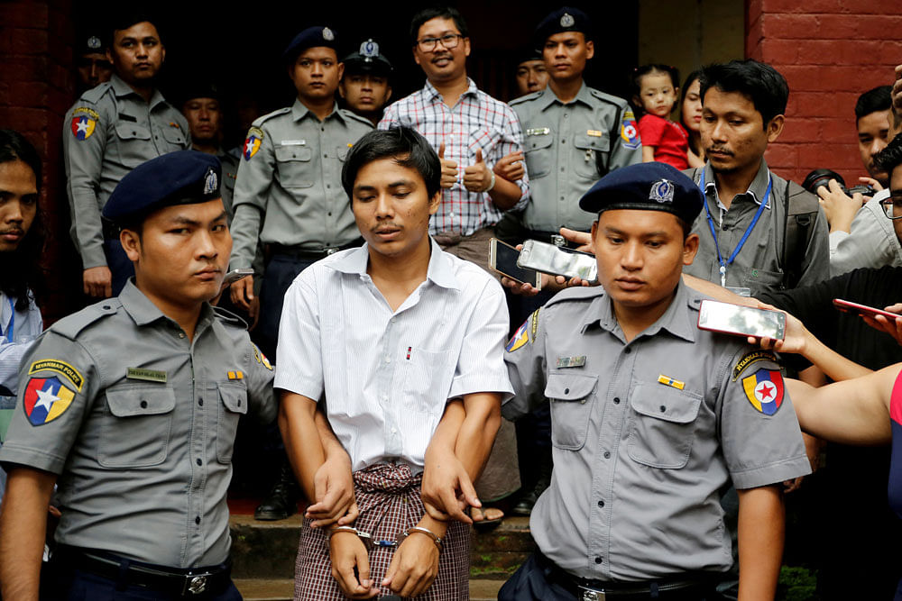 Detained Reuters journalist Kyaw Soe Oo and Wa Lone are escorted by police as they leave after a court hearing in Yangon, Myanmar on 20 August 2018. Reuters File Photo