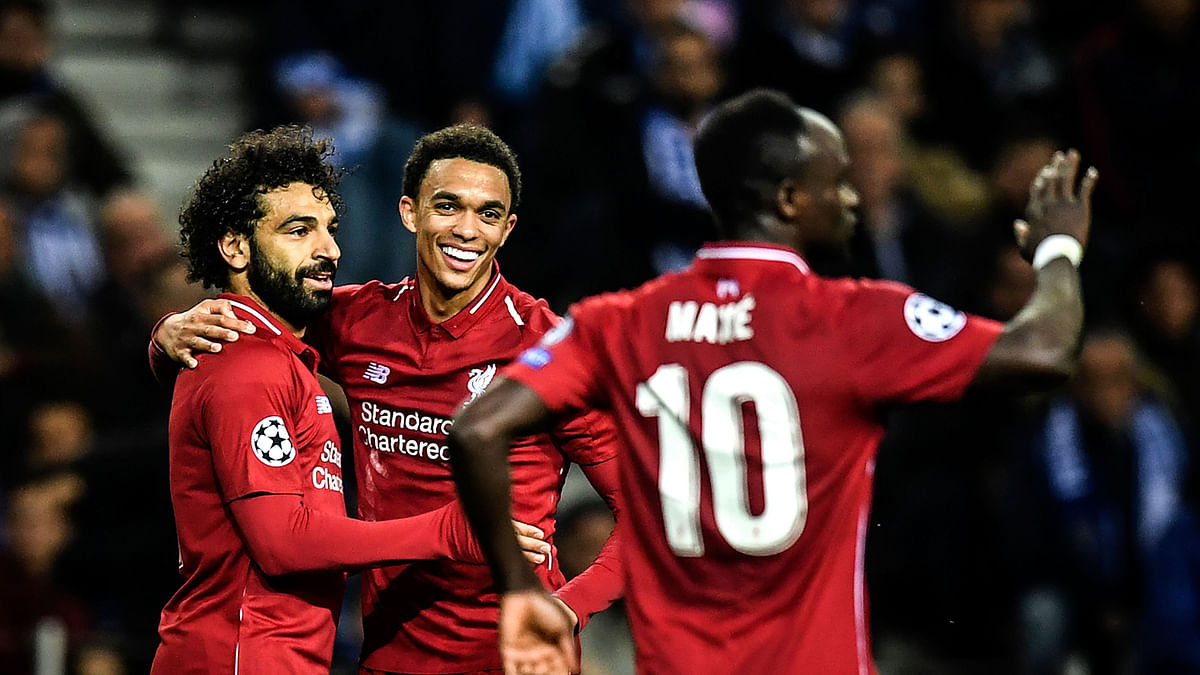 Liverpool`s Egyptian forward Mohamed Salah (L) celebrates his goal with teammates Liverpool`s British defender Trent Alexander-Arnold (C) and Liverpool`s Senegalese midfielder Sadio Mane (R) during the UEFA Champions League quarter-final second leg football match between FC Porto and Liverpool at the Dragao stadium in Porto on 17 April 2019. Photo: AFP