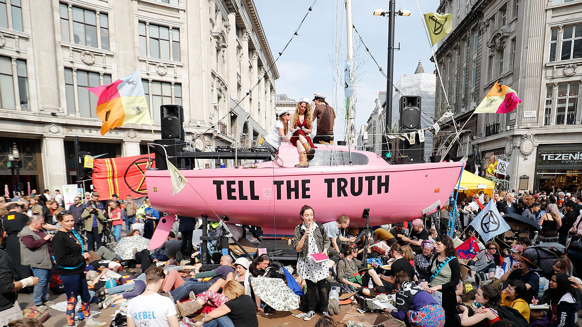 Climate change activists listen to speeches at their encampment blocking the road junction at Oxford Circus in the busy shopping district in central London on 18 April 2019 during the fourth day of an environmental protest by the Extinction Rebellion group. Photo: AFP