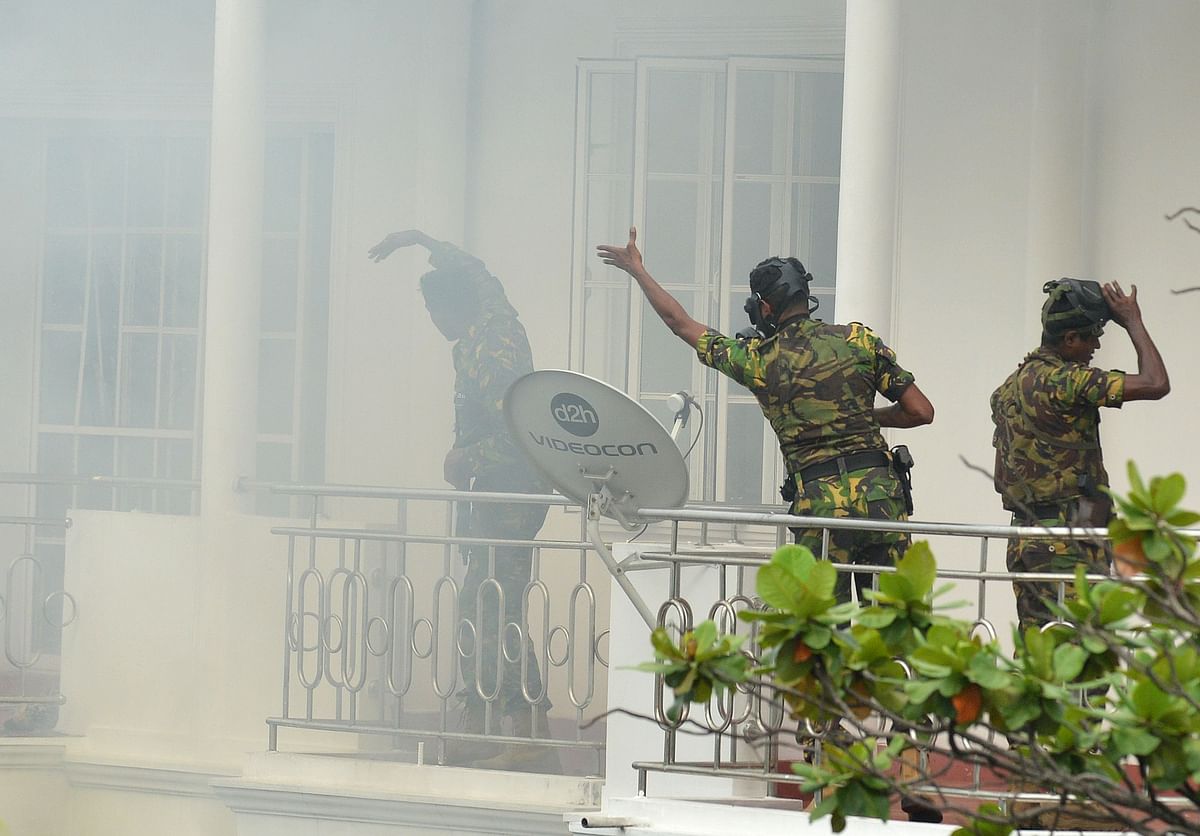 Sri Lankan Special Task Force (STF) personnel gesture outside a house during a raid -- after a suicide blast had killed police searching the property -- in the Orugodawatta area of the capital Colombo on 21 April, 2019, following a series of blasts in churches and hotels. Photo: AFP