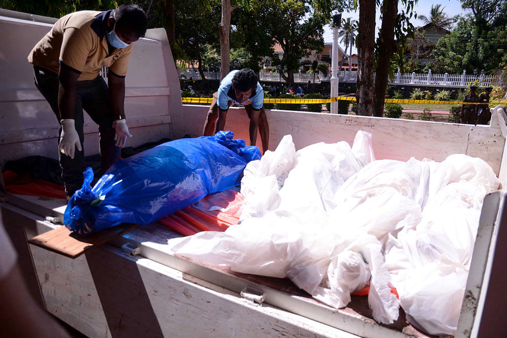 Dead bodies are being carried by Sri Lankan men outside the St Sebastian`s Church at Katuwapitiya in Negombo on 21 April, 2019, following a bomb blast during the Easter service that killed at least 290 people. Photo: AFP