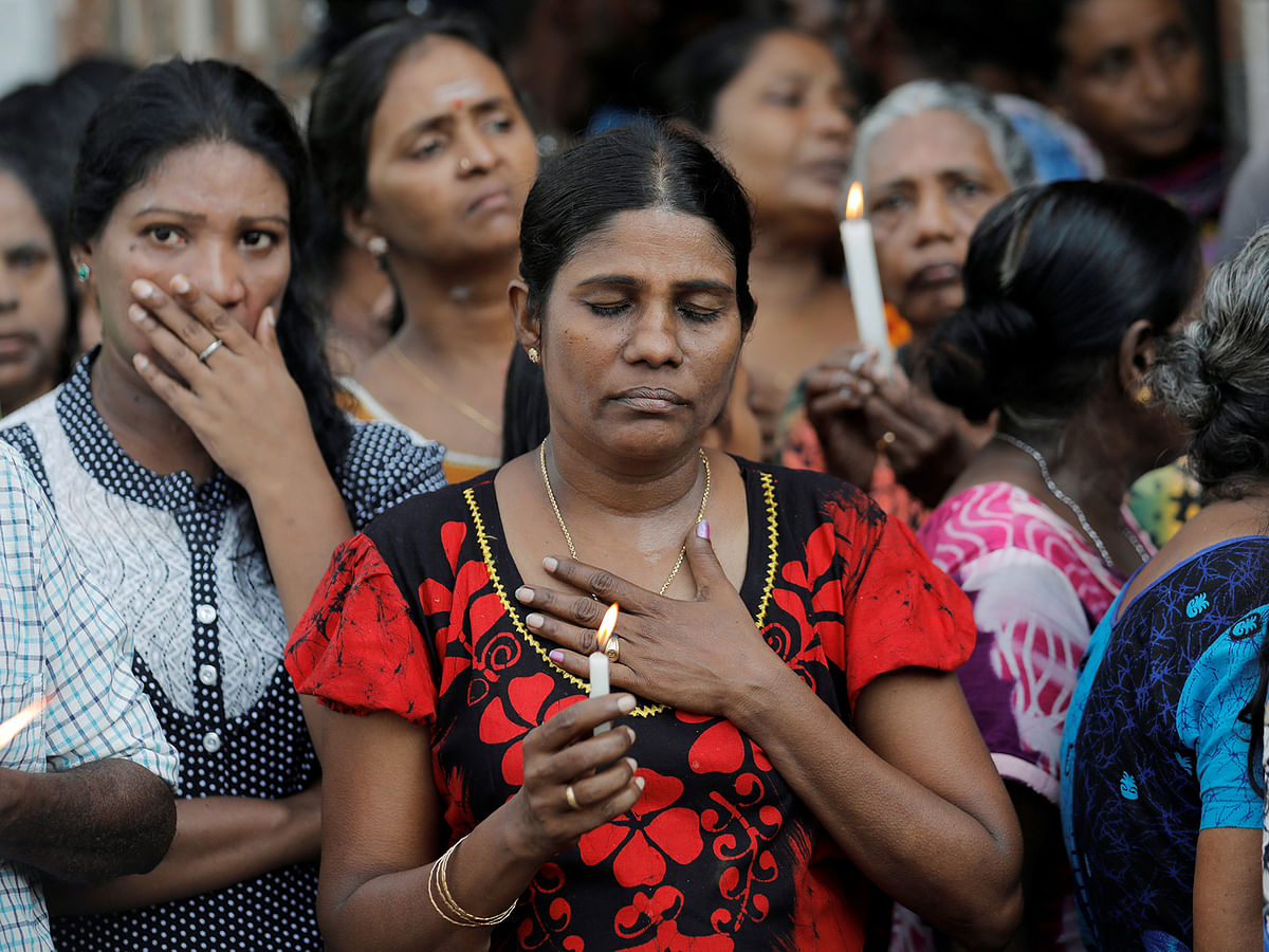 People react as silence is observed as a tribute to victims two days after a string of suicide bomb attacks on churches and luxury hotels across the island on Easter Sunday, during a memorial service in Colombo, Sri Lanka on 23 April 2019. Photo: Reuters