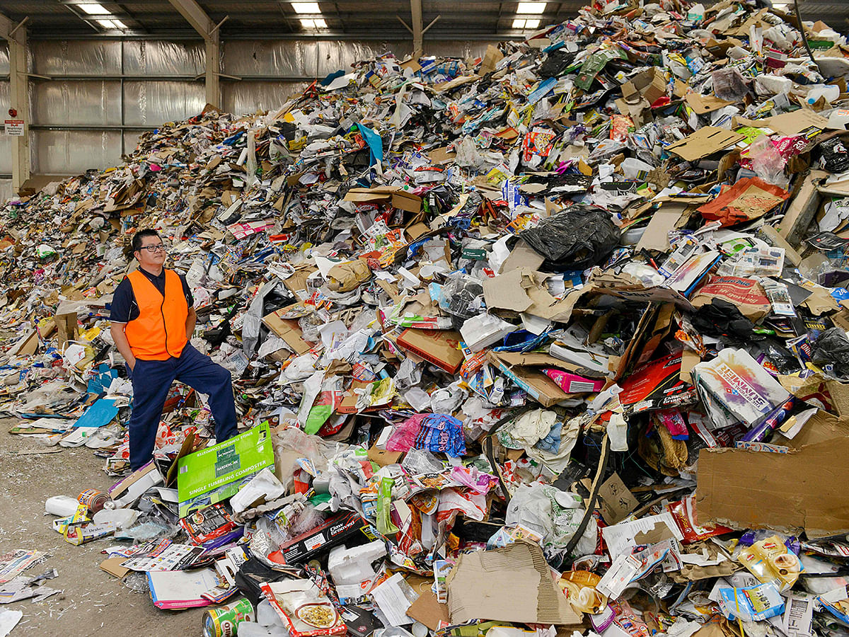 This photo taken on 17 April, 2019 shows Northern Adelaide Waste Management Authority supervisor Thao Nguyen posing amongst items set for recycling at their site in Edinburgh, near Adelaide. Photo: AFP
