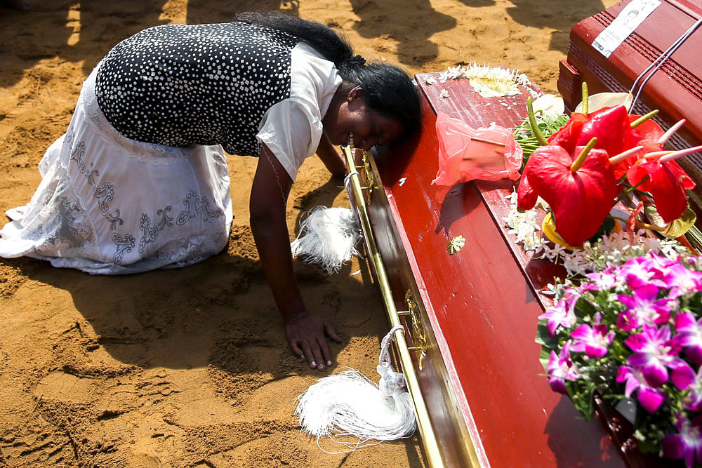 A woman reacts during a mass burial of victims, two days after a string of suicide bomb attacks on churches and luxury hotels across the island on Easter Sunday, at a cemetery near St. Sebastian Church in Negombo, Sri Lanka on 23 April 2019. Photo: Reuters