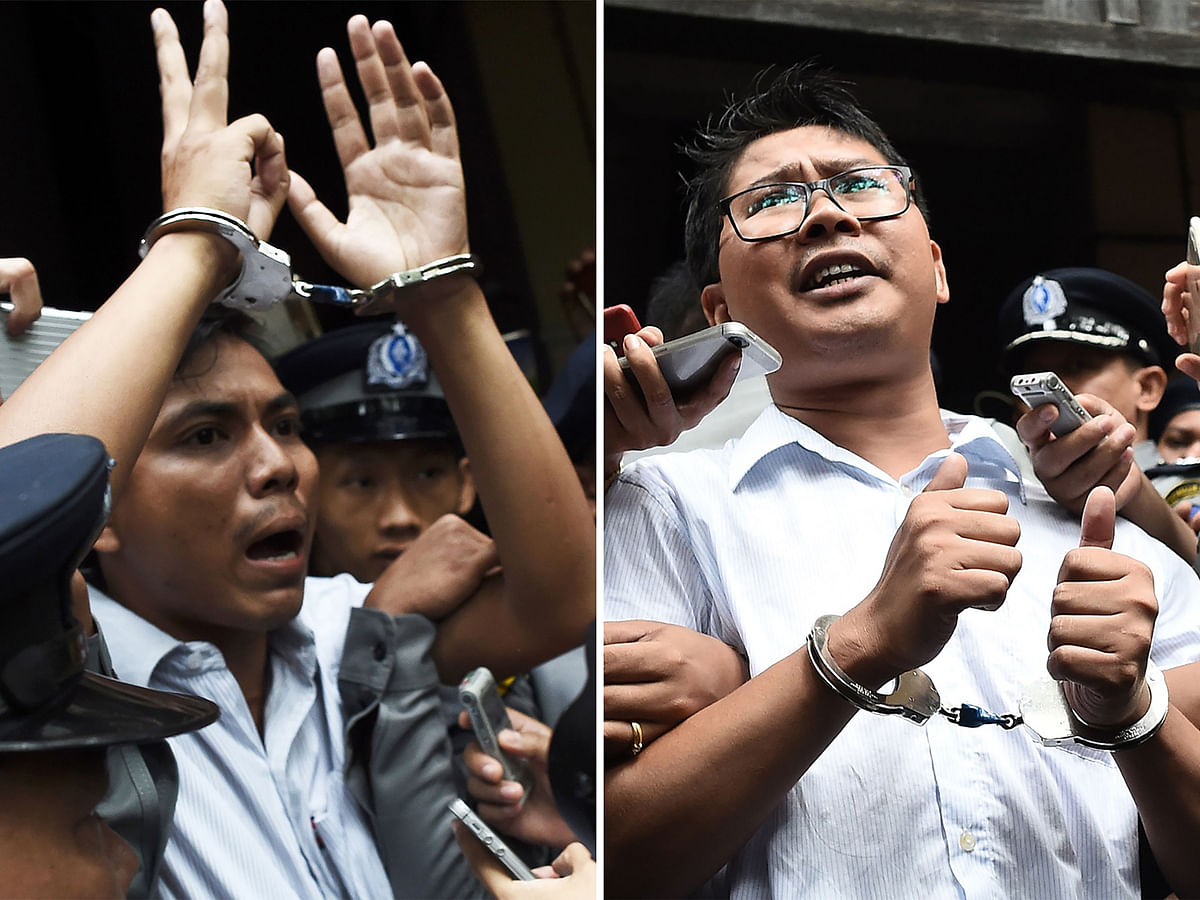 This file combination of photos taken on 3 September, 2018 shows journalists Kyaw Soe Oo (L) and Wa Lone being escorted by police after their sentencing by a court to jail in Yangon. Photo: AFP