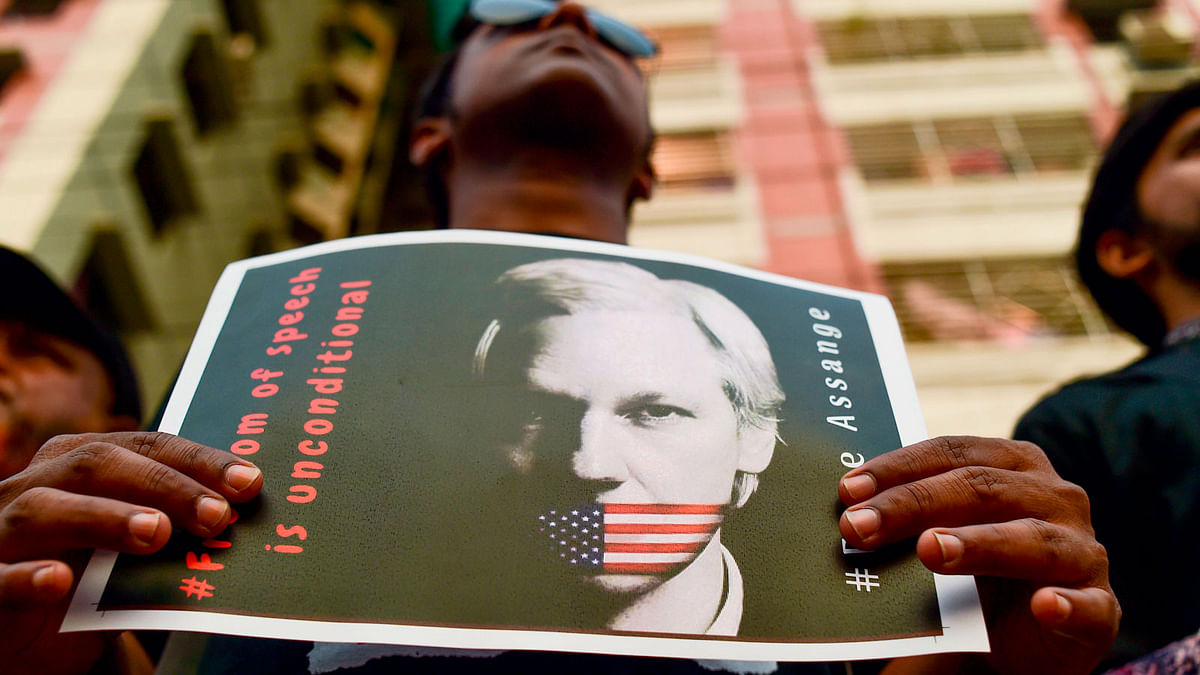 An activist holds a placard next to others while forming a human chain calling for the freedom of the international non-profit organisation`WikiLeaks` founder Julian Assange, in Dhaka on 23 April 2019. WikiLeaks founder Julian Assange`s seven-year hideout in Ecuador`s London embassy dramatically ended on 11 April when British police dragged him out and arrested him on a US extradition request. Photo: AFP