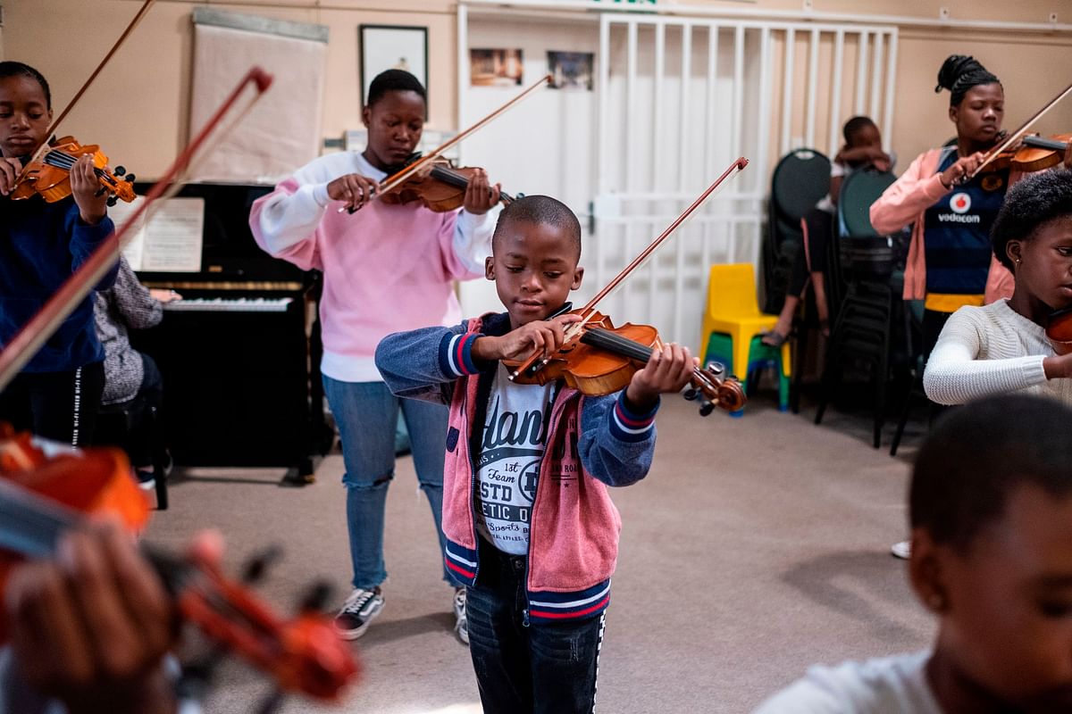 A young child plays the violin during a lesson with Buskaid at the Reformed Presbyterian Church in Diepkloof, Soweto, on 13 April 2019. Photo: AFP