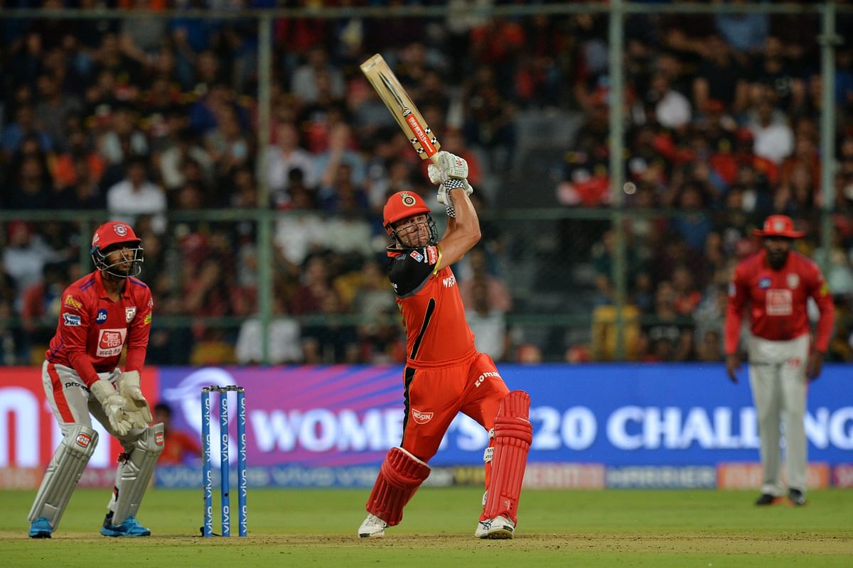 Royal Challengers Bangalore batsman Marcus Stoinis (C) plays a shot while Kings XI Punjab wicket keeper Nicholas Pooran (L) looks on during the 2019 Indian Premier League (IPL) Twenty20 cricket match at The M Chinnaswamy Stadium in Bangalore on 24 April 2019. Photo: AFP
