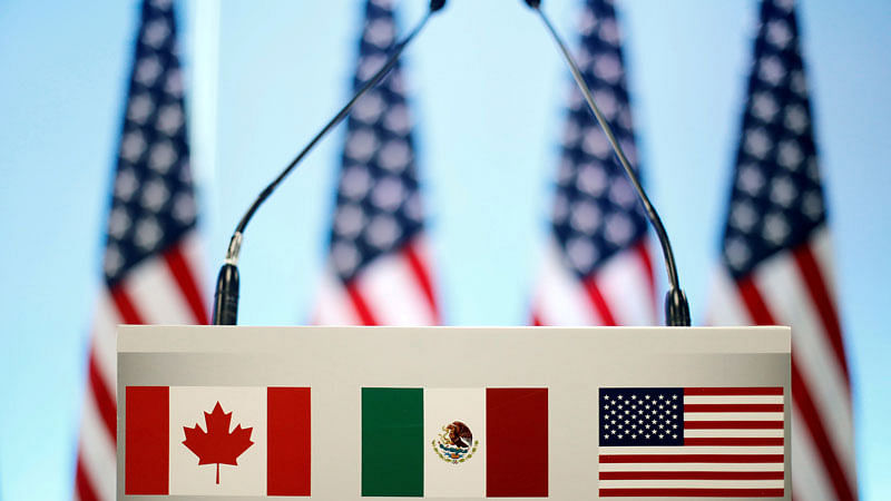 The flags of Canada, Mexico and the US are seen on a lectern before a joint news conference on the closing of the seventh round of NAFTA talks in Mexico City. Photo: Reuters