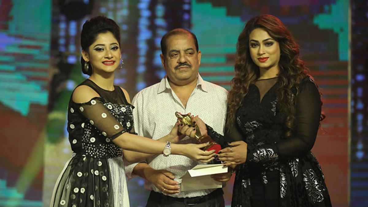 Filmmaker Sohanur Rahman Sohan and actress Popy hand over Best Film Actress award to Puja Cherry at `Meril-Prothom Alo Puroshkar 2018` on 26 April, 2019. Photo: Prothom Alo