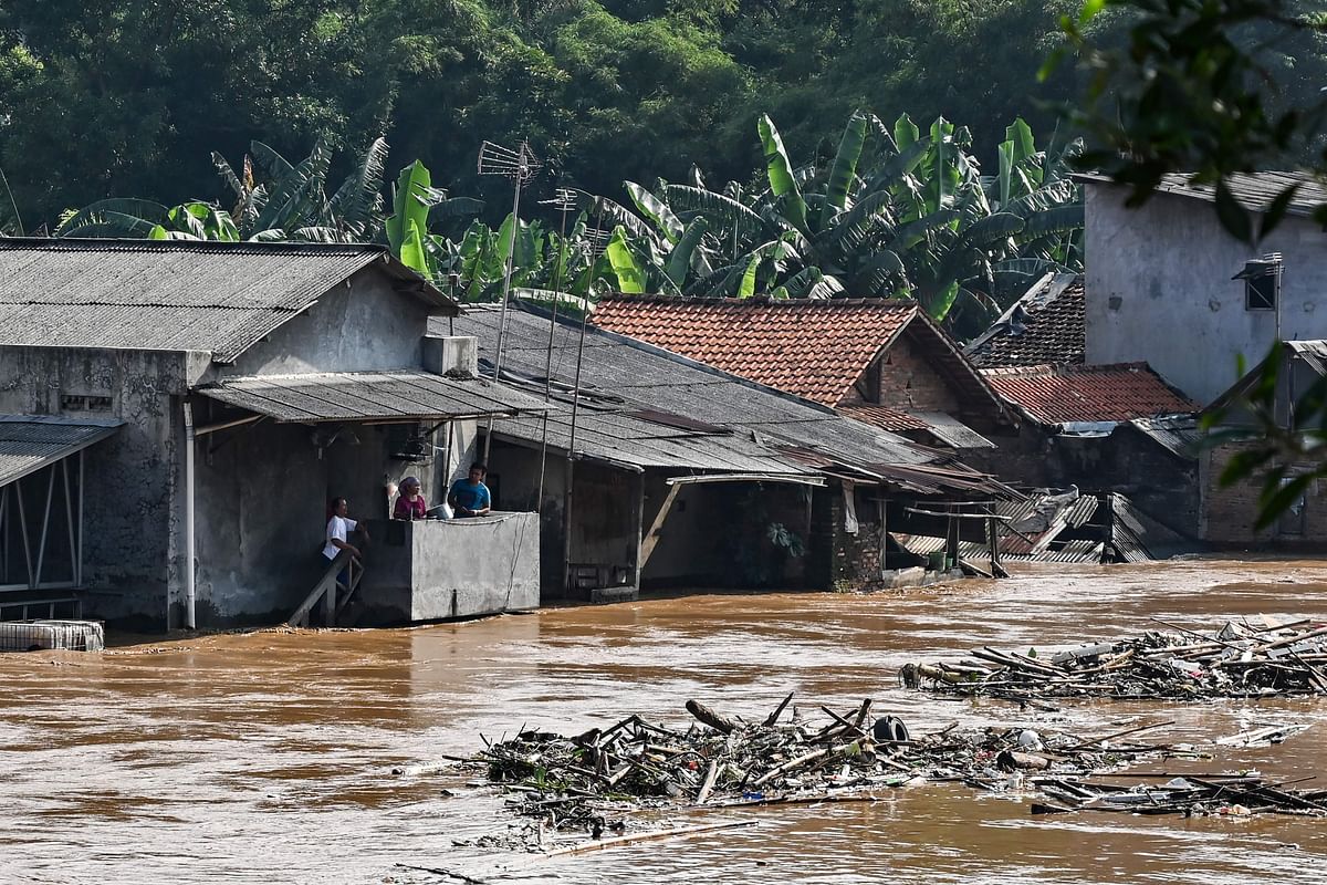 Residents stay on the second floor of their house amid floodwaters in Jakarta on 26 April after several areas were affected by heavy rainfall. Photo: AFP