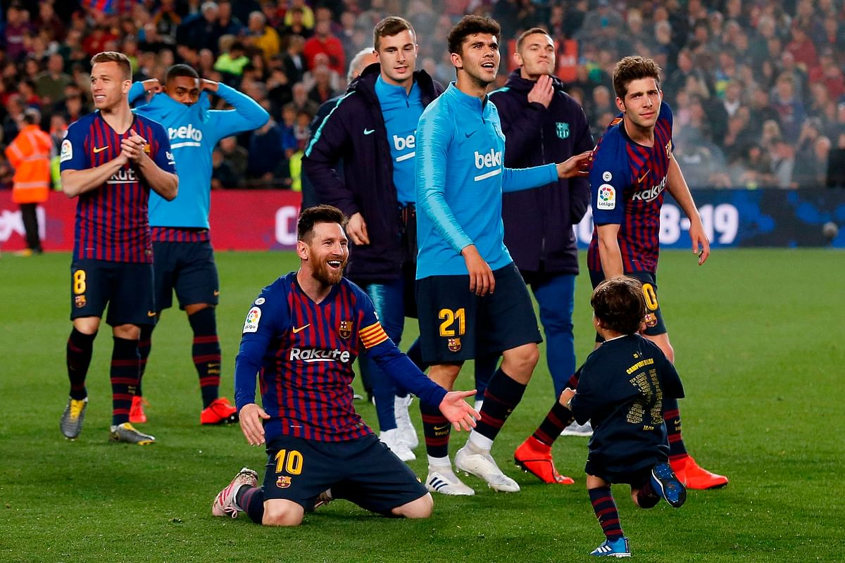 Barcelona`s Argentinian forward Lionel Messi (C) celebrates with one of his sons after Barcelona won their 26th league title at the end of the Spanish League football match between Barcelona and Levante at the Camp Nou stadium in Barcelona on 27 April 2019. Photo: AFP