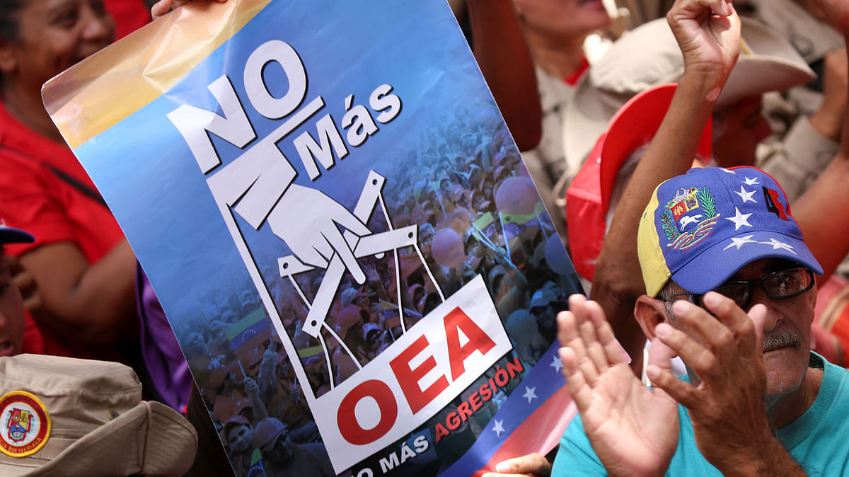 Supporters of Venezuela`s president Nicolas Maduro take part in a rally against the Organization of American States (OAS) in Caracas, Venezuela on 27 April 2019. The placard reads, `No more OAS. No more aggression`. Photo: Reuters
