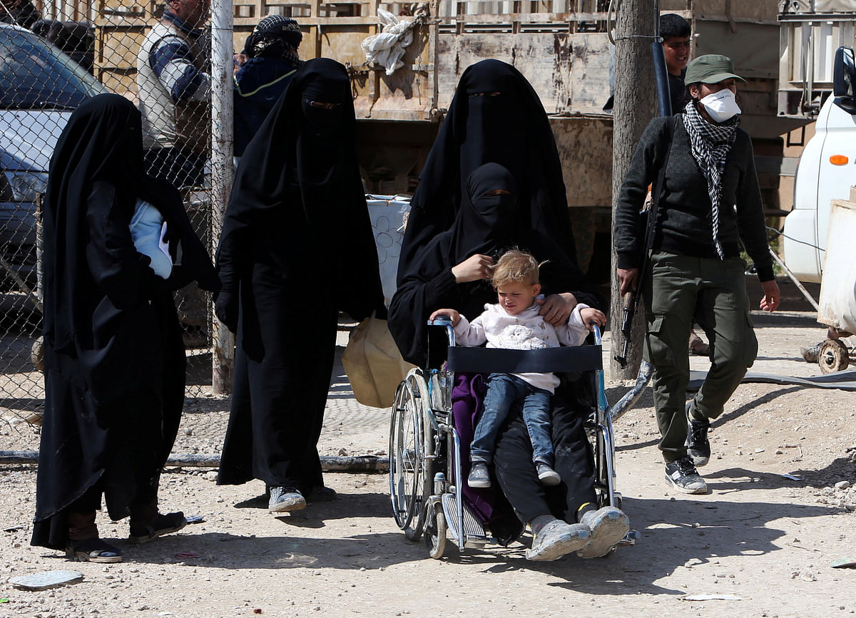The wife of an Islamic State militant sits in a wheelchair with her son on her lap at al-Hol displacement camp in Hasaka governorate.