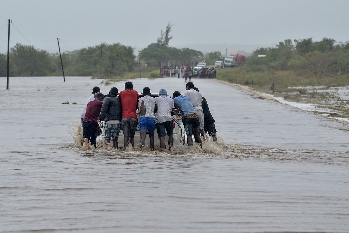 Residents push a car through the floods in Mazive, southern Mozambique, on April 28, 2019. Heavy rains from a powerful cyclone lashed northern Mozambique on 27 April 2019, sparking fears of flooding as aid workers arrived to assess the damage, just weeks after the country suffered one of the worst storms in its history. Photo: AFP