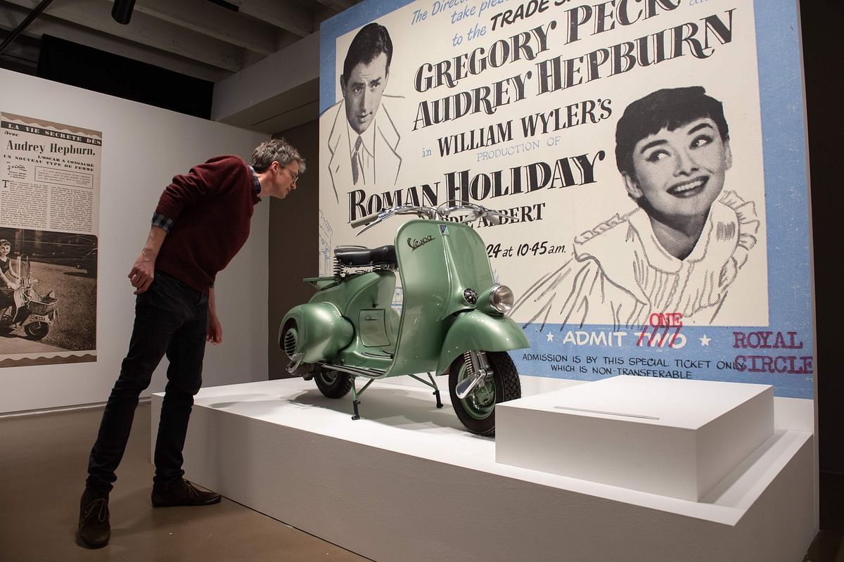 A visitor looks at a scooter on the eve of the inauguration on the exhibition on Audrey Hepburn and his father actor and realisator Mel Ferrer at the Espace Vandenborgh in Brussels on 29 April 2019. Photo: AFP