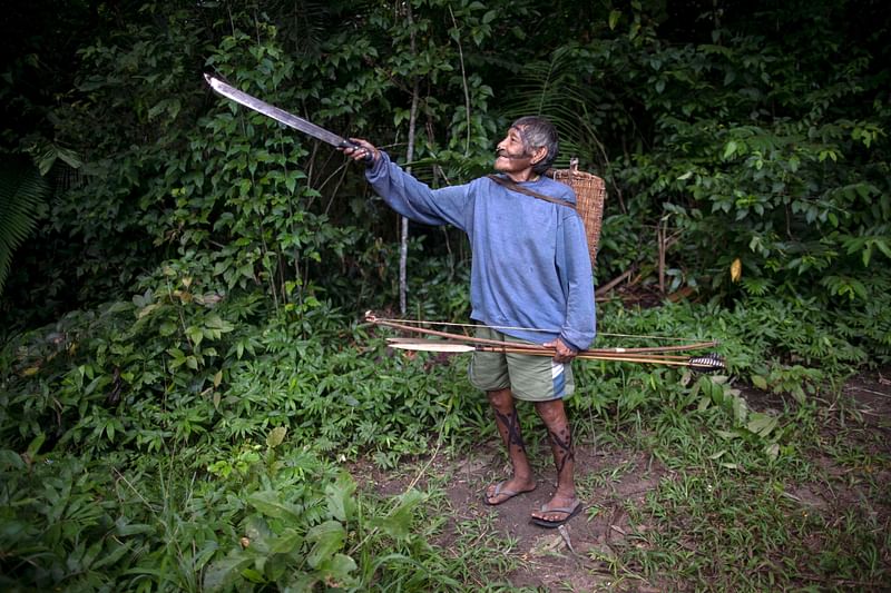 An Arara indigenous man points his way before a walk to collect bananas at the Laranjal tribal camp, in Arara Indigenous territory, in the northern Brazilian Amazon rainforest, on 15 March 2019. Photo: AFP