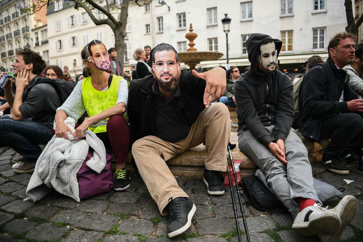 A protester wearing a mask depicting Alexandre Benalla, a French president`s former bodyguard had been caught on video roughing up protesters during a May Day rally on the Contrescarpe square in Paris, takes part in an event called `BenallApero`, on 1 May 2019, on the square. Paris riot police fired teargas as they squared off against hardline demonstrators among tens of thousands of May Day protesters, who flooded the city in a test for France`s zero-tolerance policy on street violence. Photo: AFP