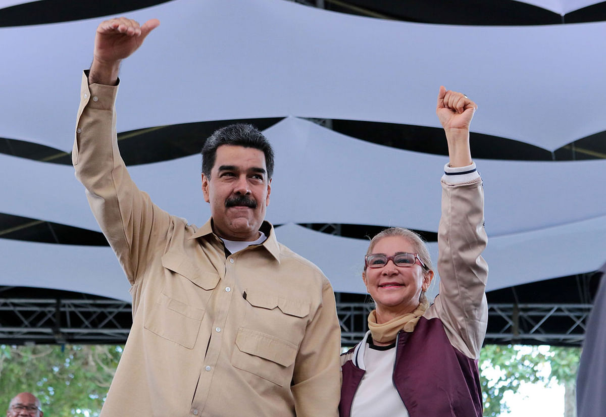 Handout picture released by Miraflores Palace press office showing Venezuela`s president Nicolas Maduro and his wife Cilia Flores raising their arms during a meeting with young people in the framework of the programme `The Great Mission Chamba Juvenil` in Fuerte Tiuna, Caracas, on 2 May. Photo: AFP